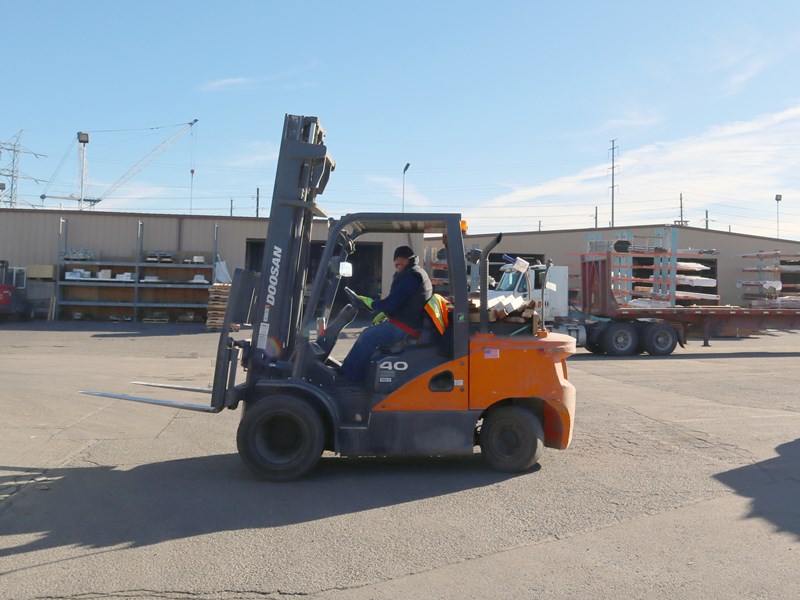 Forklift and forklift operator in the yard at Direct Lumber and Door of Colorado